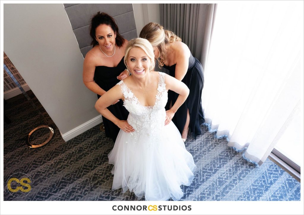bride getting into her wedding dress at Fairmont Hotel in Washington, DC photography by Connor Studios 