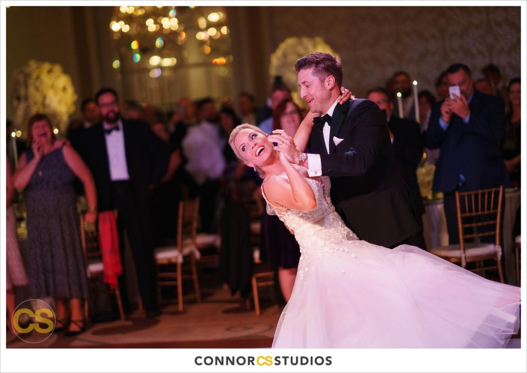 first dance during luxury wedding with candles and gold colors in the ballroom at Fairmont Hotel in Washington, DC photography by Connor Studios 