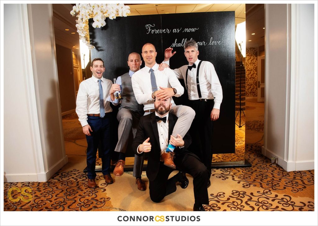 guys in photo booth during luxury wedding with candles and gold colors in the ballroom at Fairmont Hotel in Washington, DC photography by Connor Studios 