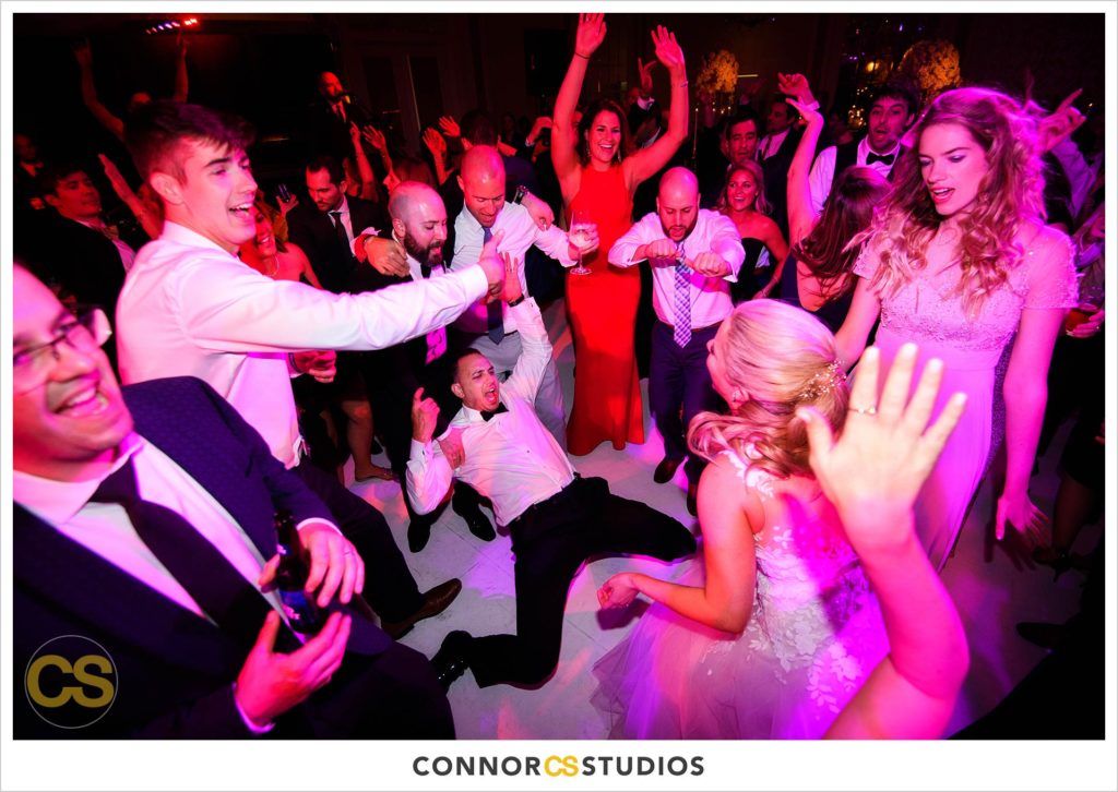 dance floor full of colors in pink and red and blue during wedding in the ballroom at Fairmont Hotel in Washington, DC photography by Connor Studios 