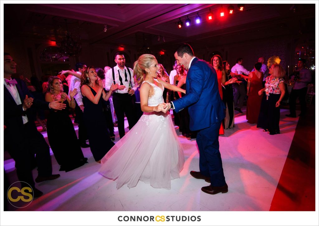 dance floor full of colors in pink and red and blue during wedding in the ballroom at Fairmont Hotel in Washington, DC photography by Connor Studios 