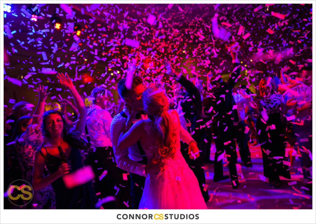 dance floor with confetti canon full of colors in pink and red and blue during wedding in the ballroom at Fairmont Hotel in Washington, DC photography by Connor Studios 