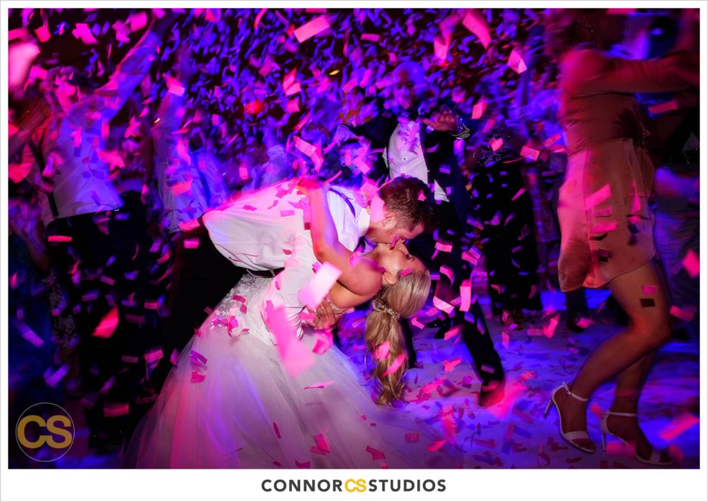 dance floor with confetti canon full of colors in pink and red and blue during wedding in the ballroom at Fairmont Hotel in Washington, DC photography by Connor Studios 