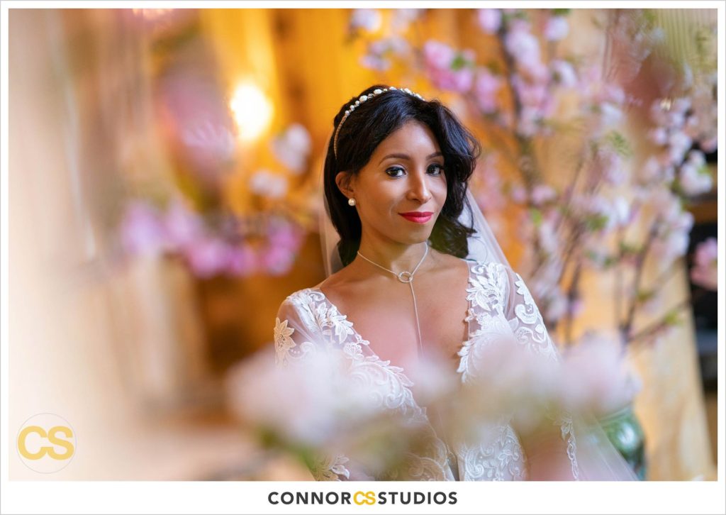 photograph of bride surrounded by cherry blossoms in the lobby of the Willard Intercontinental in Washington, DC by Connor Studios