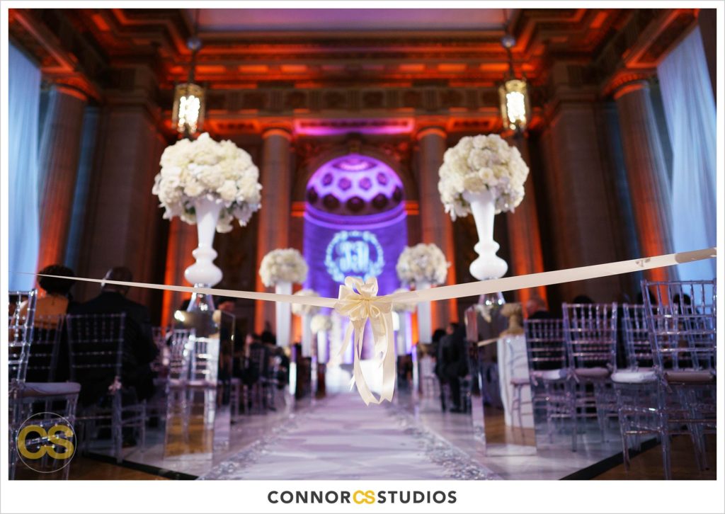 wedding in reds and purple with tall floral arrangment at the Andrew W. Mellon Auditorium in Washington, DC by Connor Studios