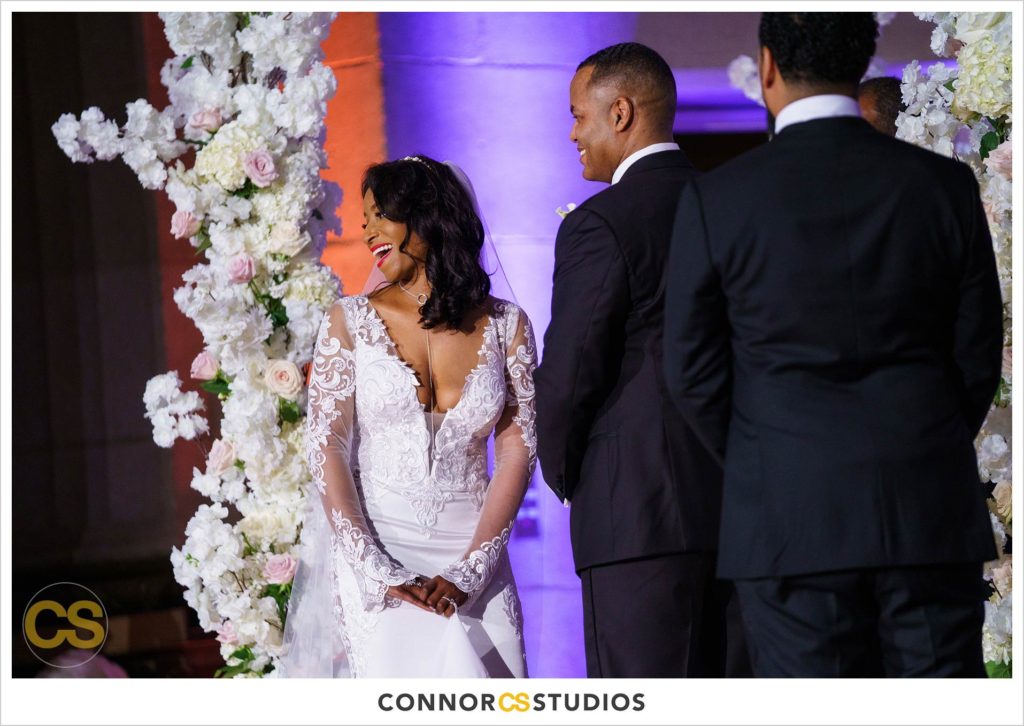bride and groom laughing at their wedding ceremony at the Andrew W. Mellon Auditorium in Washington, DC by Connor Studios