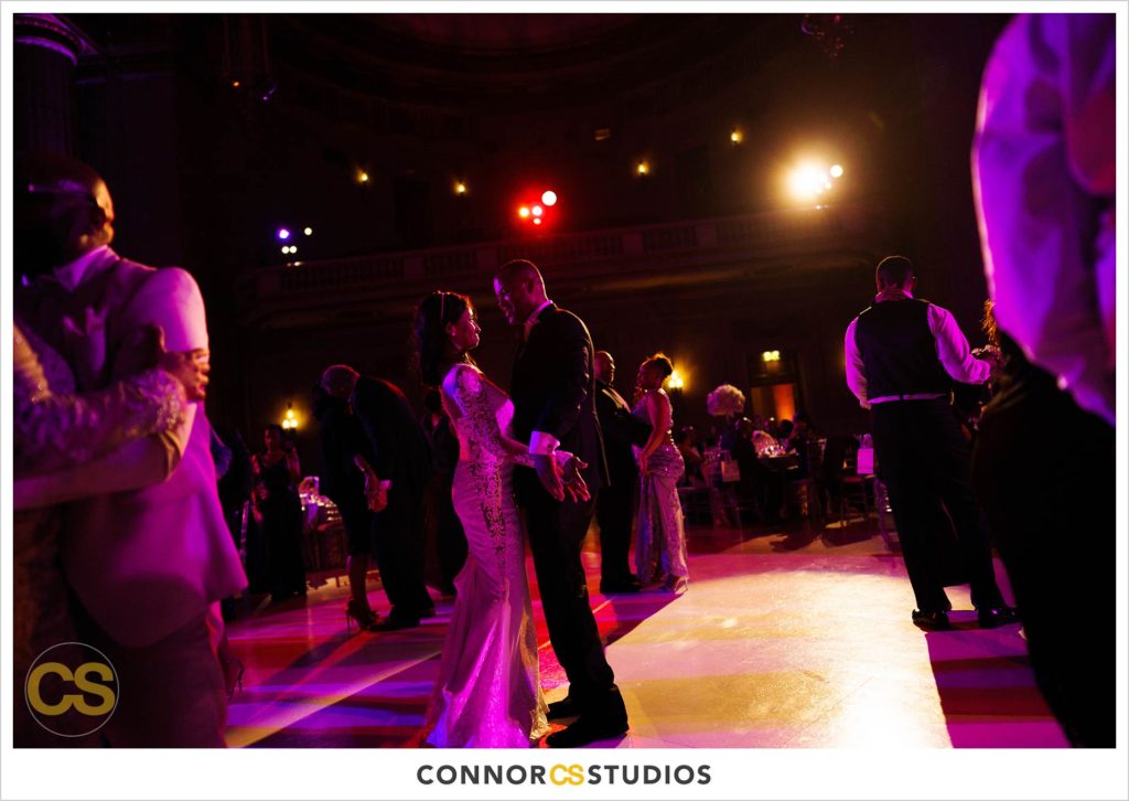 first dance at wedding with purple lighting at the Andrew W. Mellon Auditorium in Washington, DC by Connor Studios