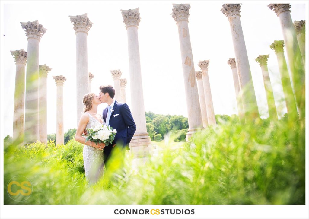 photograph of bride and groom kissing on their wedding day for portraits at the National Capitol Columns and the bonsai gardens at the national arboretum in washington, dc by connor studios