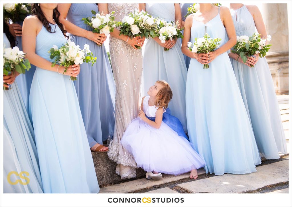 photograph of bride, bridesmaids in baby blue dresses and cute flower girl on their wedding day for portraits at the National Capitol Columns at the national arboretum in washington, dc by connor studios