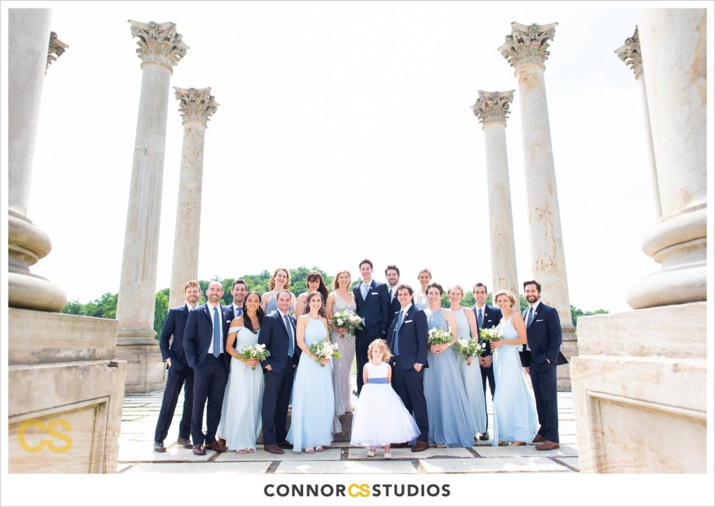 photograph of bride and groom with their wedding party on their wedding day for portraits at the National Capitol Columns at the national arboretum in washington, dc by connor studios