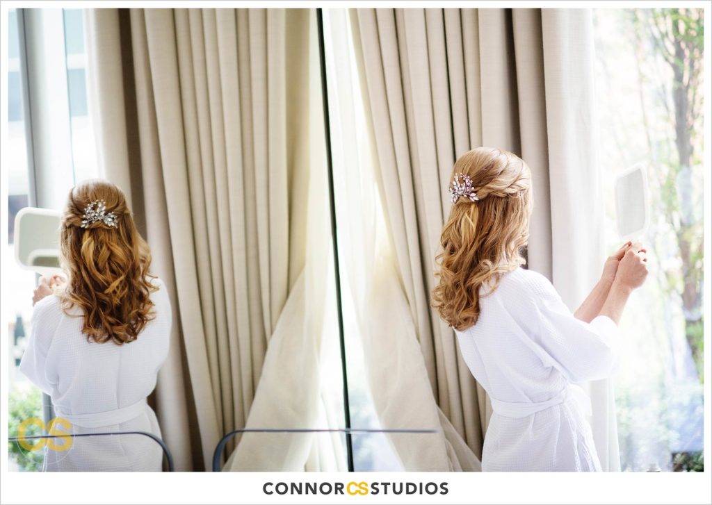 bride looking at her hair done by makeup by ana b at the conrad washington dc hotel by connor studios