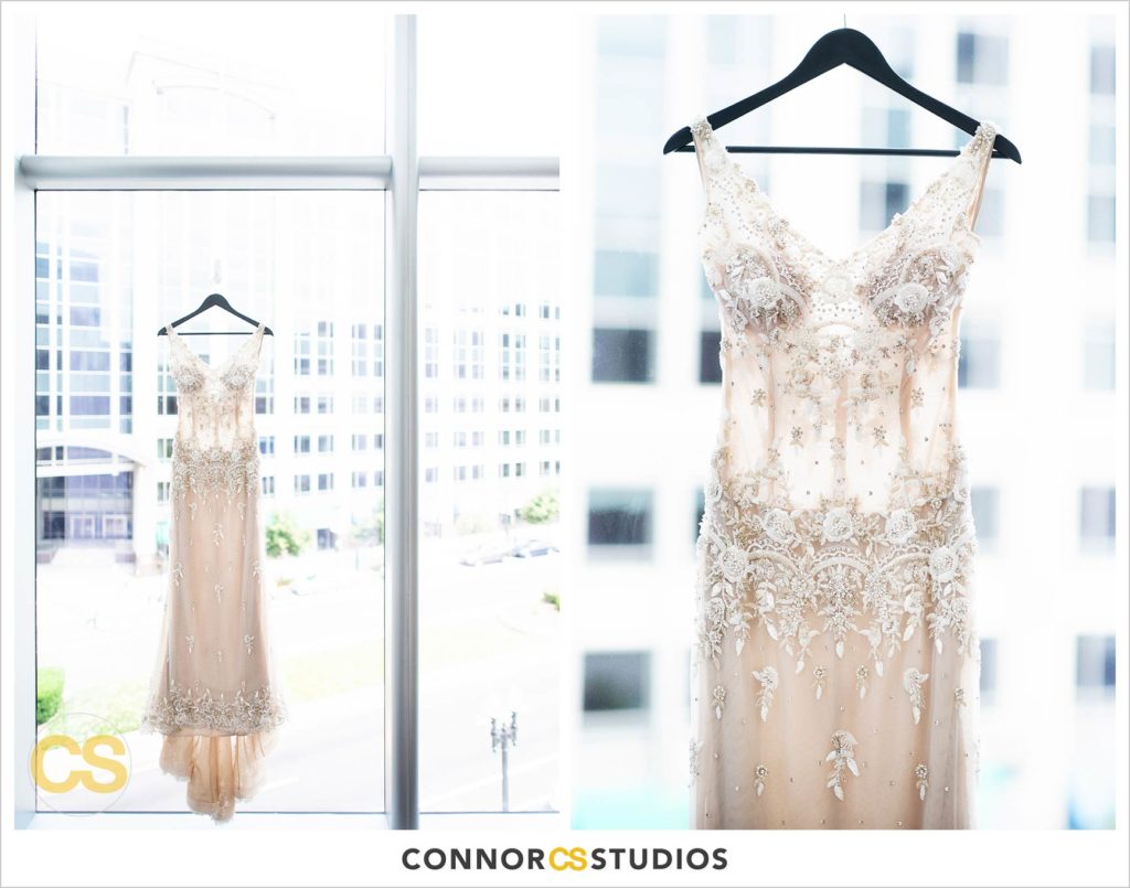 detail photograph of bride’s wedding dress hanging in the window at the conrad washington dc hotel by connor studios