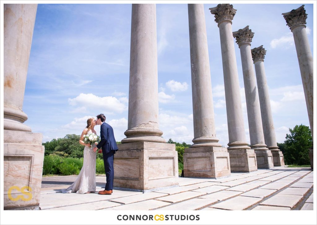 photograph of bride and groom kissing at first look on their wedding day at the National Capitol Columns at the national arboretum in washington, dc by connor studios