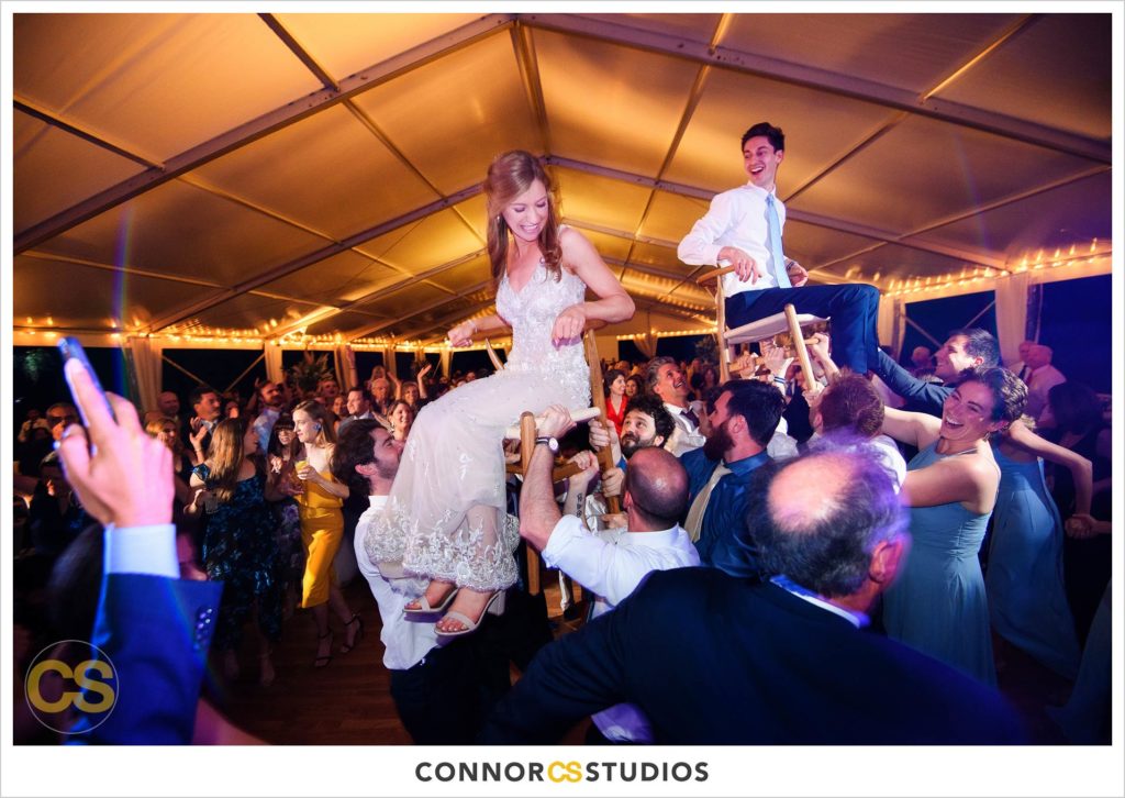 dancing the hora at large tented outdoor summer wedding reception at the national arboretum in washington, dc by connor studios