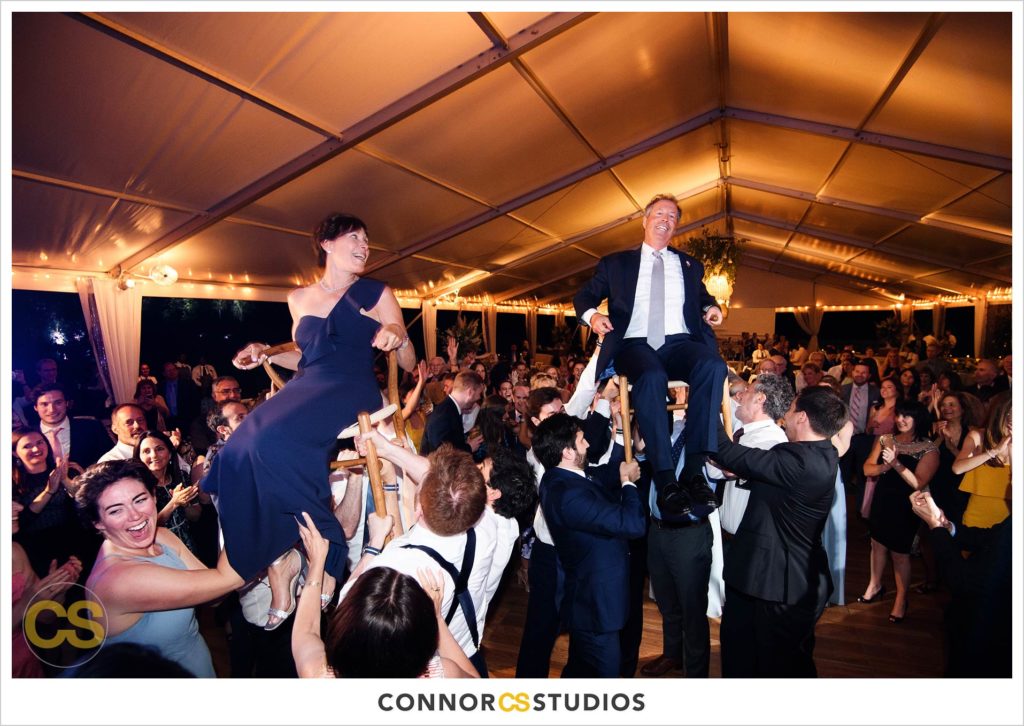 dancing the hora at large tented outdoor summer wedding reception at the national arboretum in washington, dc by connor studios