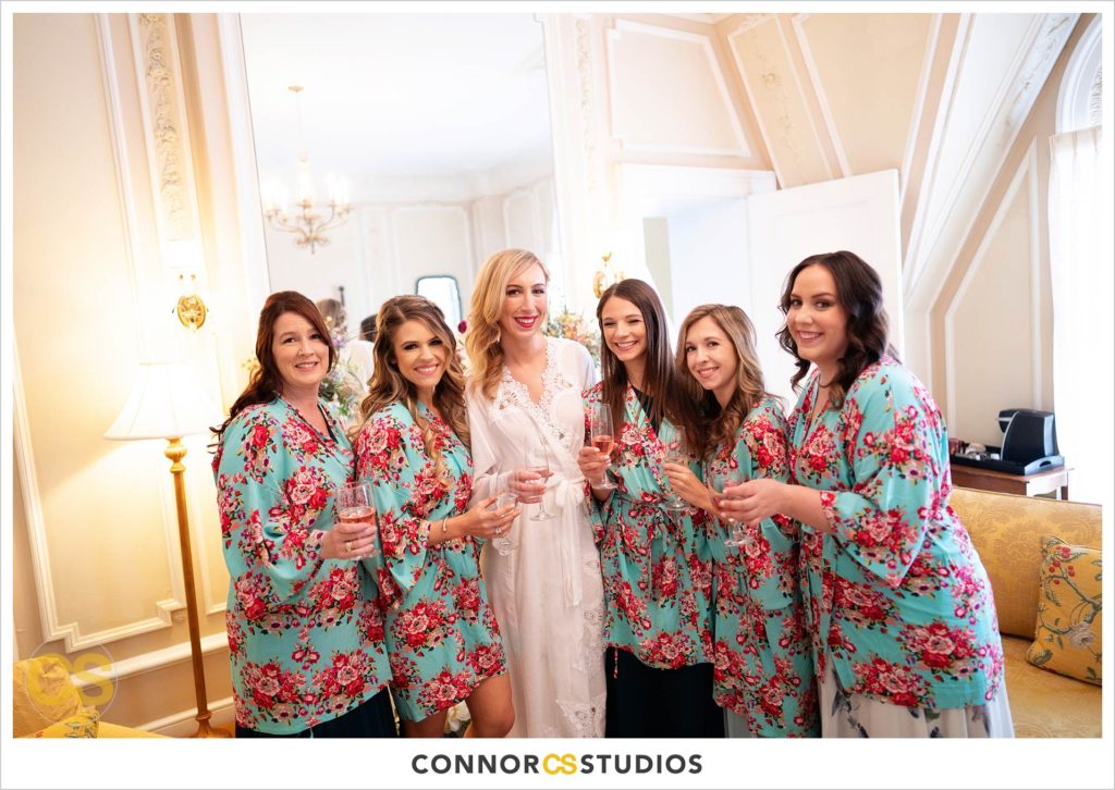 bridesmaids and bride in flower print robes with champagne getting ready at the Cosmos Club in Washington, DC by Connor Studios
