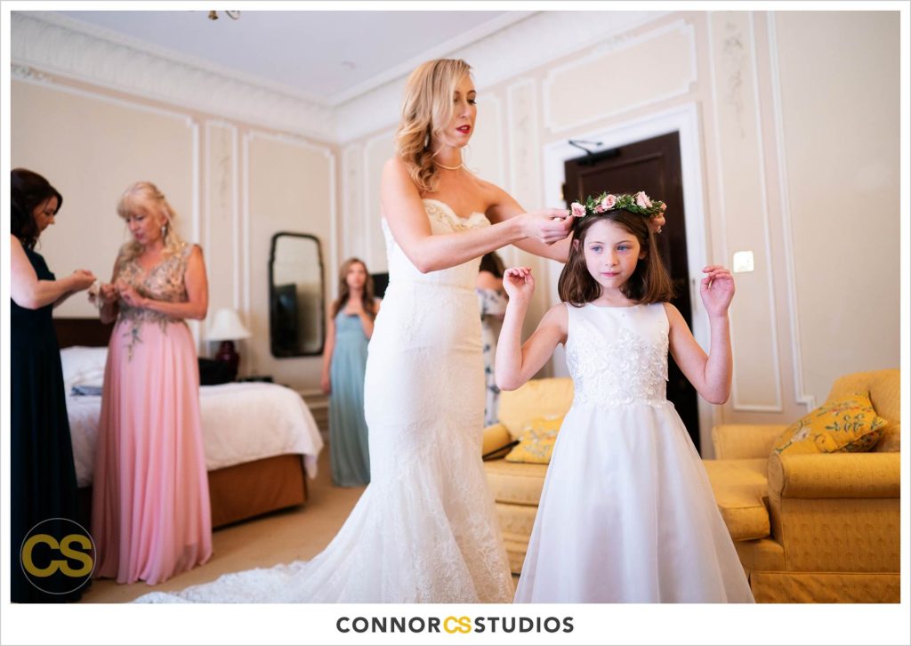 bride putting flower crown on flower girl at the Cosmos Club in Washington, DC by Connor Studios