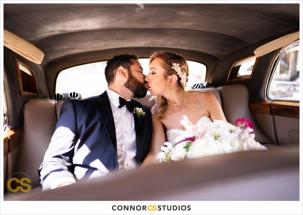 bride and groom kissing after their wedding in a vintage rolls royce at st. patrick's catholic church in washington, dc by connor studios