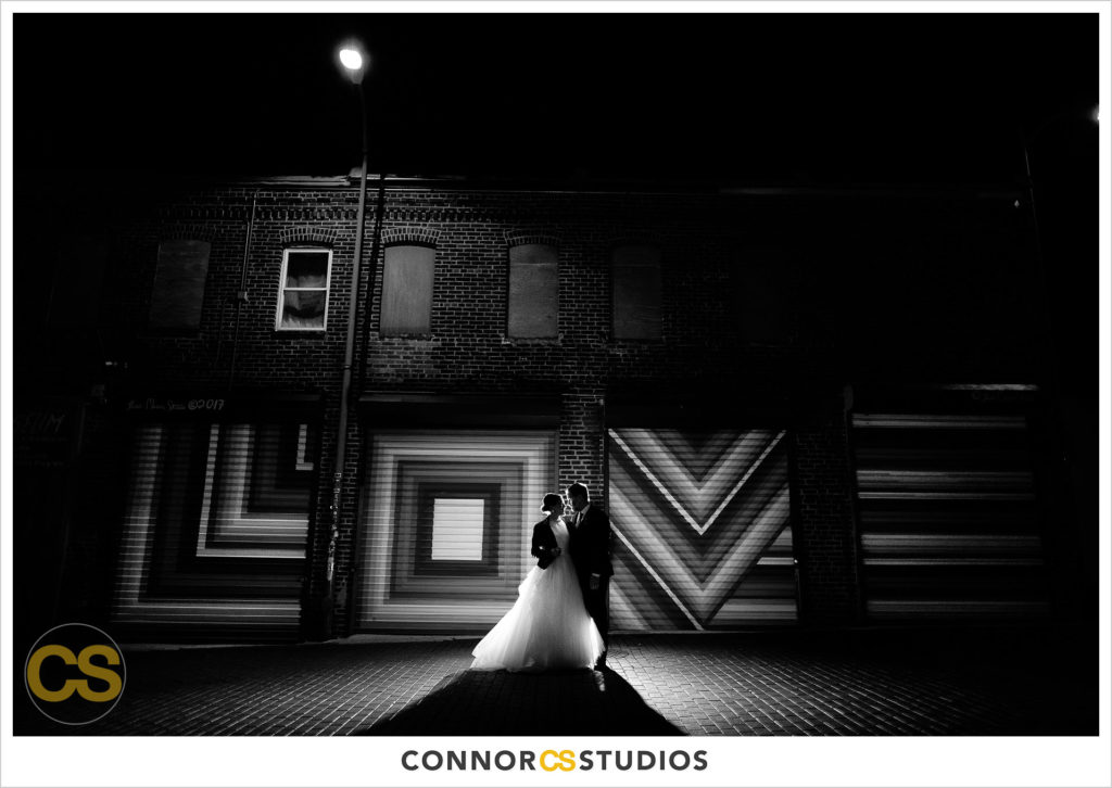 new year's eve wedding portrait of bride and groom at love graffiti doors in blagden alley near long view gallery in washington, dc by connor studios