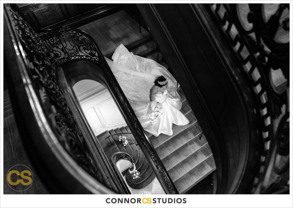 luxury wedding photography of the bride walking down the stairs in her wedding dress at the cosmos club during covid-19 in washington, dc by connor studios
